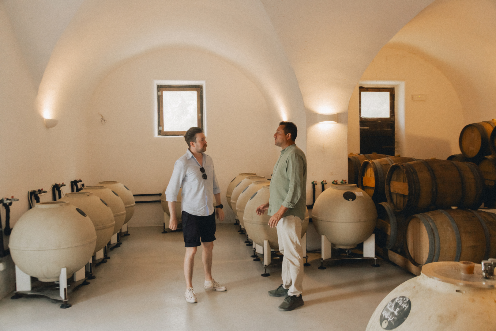 Clay amphorae and oak barrels — where Santorini's wine story begins. nside a Santorini Winery — Ancient Meets Modern