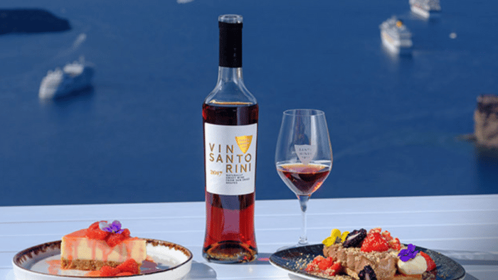 Vinsanto dessert wine served with sweets overlooking the Santorini caldera.