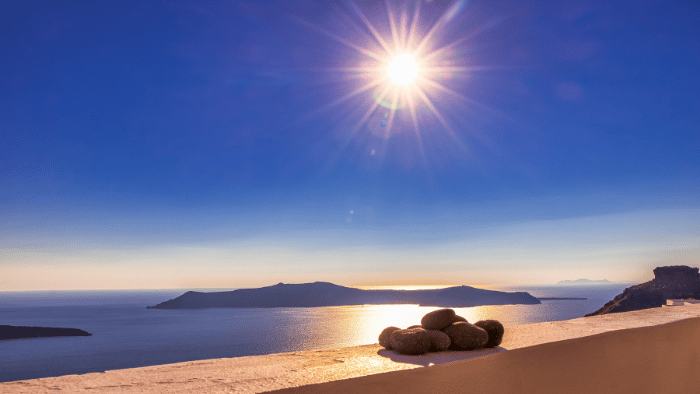 Bright sunny day over the Santorini caldera with the volcanic island of Nea Kameni in the distance, ideal in summer