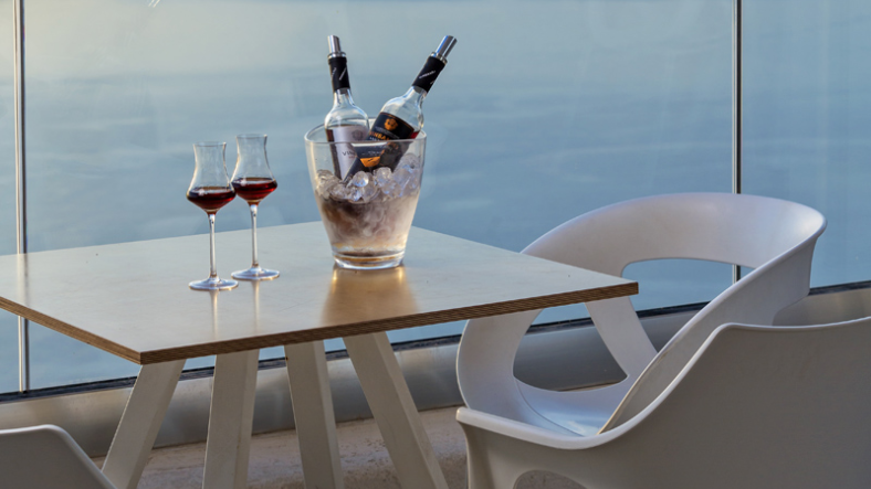 Vinsanto wine served at a Santorini winery tasting table with caldera ocean view