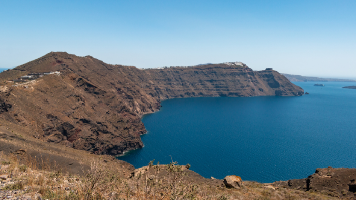 Wide view of the Santorini caldera with volcanic cliffs and deep blue Aegean Sea